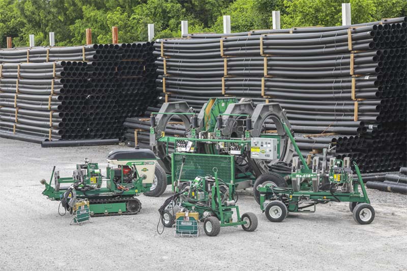 McElroy fusion machines in front of stacked HDPE pipes