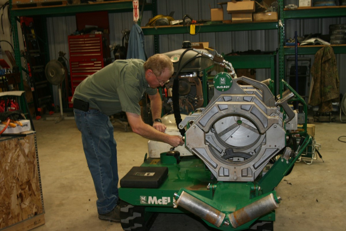 An ISCO team member performing maintenance on a McElroy fusion machine